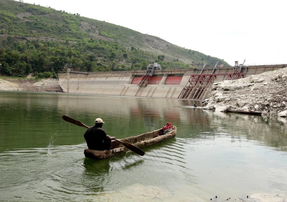 In this file photo from April 20, 2010, a man passes by the Peligre dam in central Haiti, which supplies electricity.