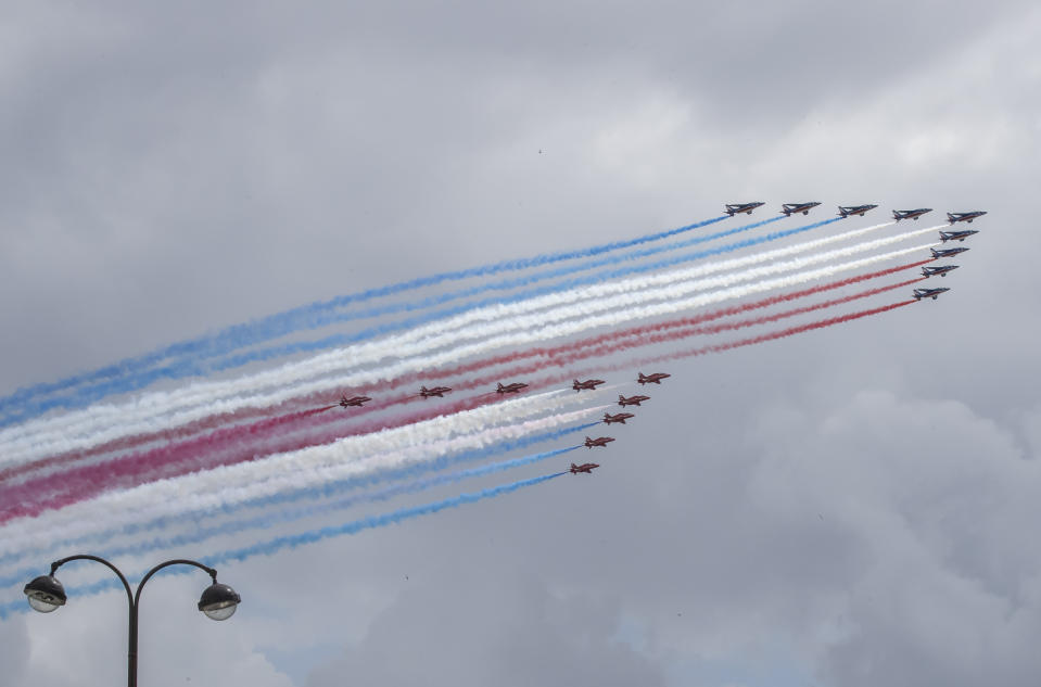 French Alpha jets of the Patrouille de France followed by the Red Arrows, officially known as the Royal Air Force Aerobatic Team spray lines of smoke in the colors of the French flag flies over Paris, Thursday, June 18, 2020, to mark the 80th anniversary of late French Gen. Charles de Gaulle's resistance call from London of June 18,1940. (AP Photo/Michel Euler)