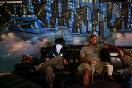 Ivy Zheng (L), 26, a student and William Harris, 29, a software engineer who are both residents of The Negev tech house relax during a Sunday "family" dinner in San Francisco, California, U.S. October 30, 2016.