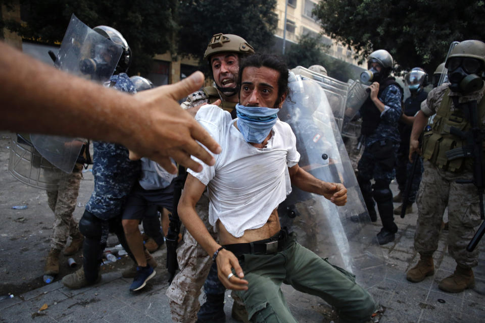 A protestor is evacuated from clashes during a protest against the political elites and the government after this week's deadly explosion at Beirut port which devastated large parts of the capital in Beirut, Lebanon, Saturday, Aug. 8, 2020. (AP Photo/Thibault Camus)