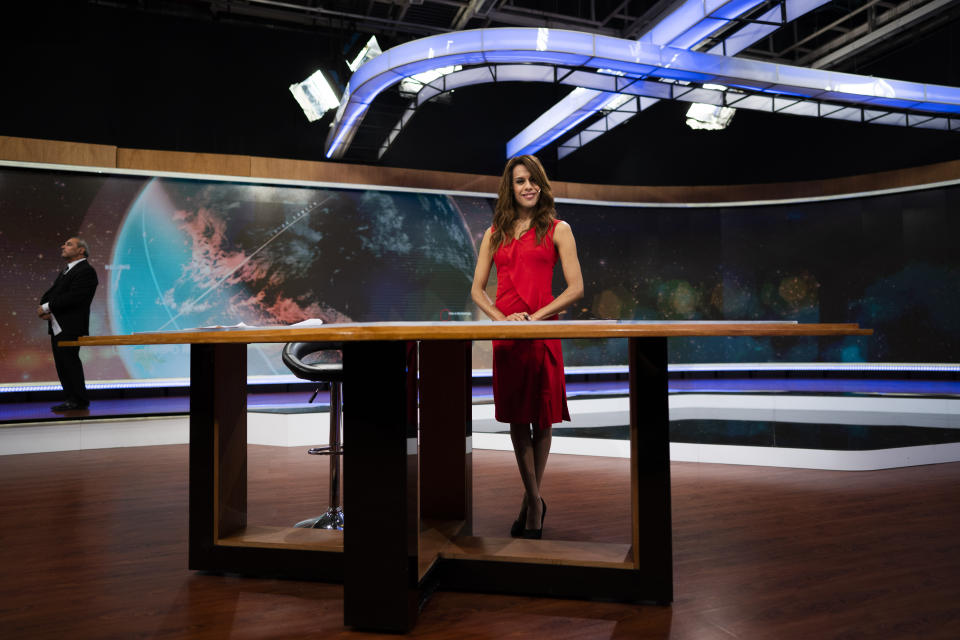 In this March 5, 2020 photo, Diana Zurco poses for a photo at the table for news anchors during a rehearsal for her debut as the country’s first transgender newscaster, in Buenos Aires, Argentina. Her job as a co-anchor of Public Television's prime time evening news program is a milestone for an excluded community that is often the target of violence and has a life expectancy roughly half that of the rest of the population. (AP Photo/Victor R. Caivano)