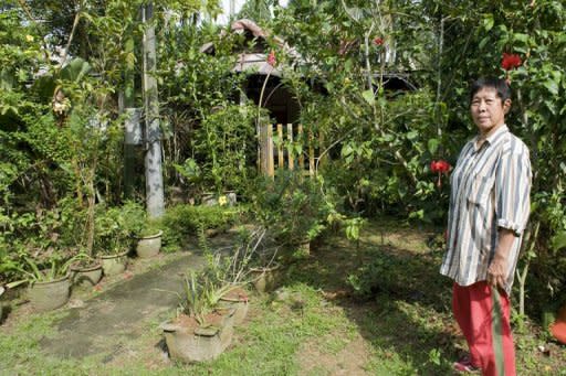 Landlady Sng Mui Hong, 57, poses for a photograph outside her Kampong Lorong Buangkok village home in Singapore in January 2010