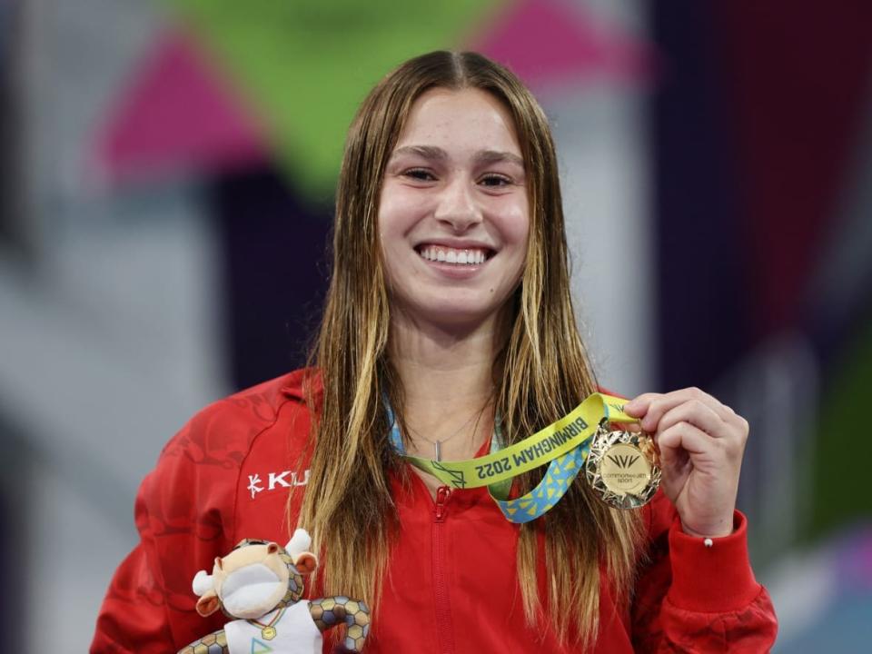 Canada's Mia Vallée poses for a photo with her gold medal after winning the women's one-metre springboard diving final on Friday at the 2022 Commonwealth Games in Birmingham, England. (Stoyan Nenov/Reuters - image credit)