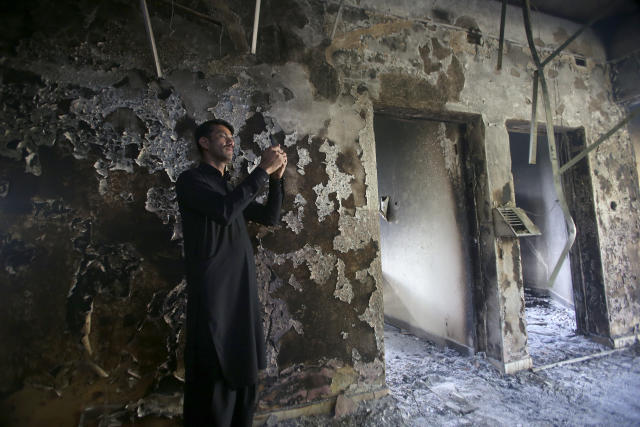 A local man takes photos with his mobile phone inside the Radio Pakistan building burnt in the Wednesday's clashes between police and the supporters of Pakistan's former Prime Minister Imran Khan, in Peshawar, Pakistan, Thursday, May 11, 2023. With Khan in custody, Pakistani authorities on Thursday cracked down on his supporters, arresting hundreds in overnight raids and sending troops across the country to rein in the wave of violence that followed his arrest earlier this week. (AP Photo/Muhammad Sajjad)
