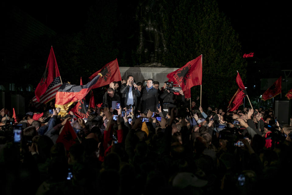 Albin Kurti, center right, leader of Self-Determination Movement (Vetevendosje), appears in front of a celebrating crowd gathered after winning the parliamentary elections in Kosovo capital Pristina early Monday, Oct. 7, 2019. Two Kosovo opposition parties emerged as the top-vote getters in Sunday's snap election of a new parliament held amid calls for leaders to resume dialogue with Serbia over normalizing ties. Self-Determination supporters took to the streets to celebrate. (AP Photo/Visar Kryeziu)