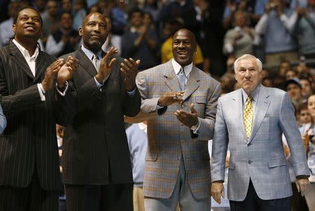 Former University of North Carolina players Sam Perkins, James Worthy, and Michael Jordan, along with former North Carolina head basketball coach Dean Smith (L-R) watch a presentation honoring the 1957 and 1982 national championship teams at halftime of the NCAA basketball game between North Carolina and Wake Forest University in Chapel Hill, North Carolina, in this file photo taken February 10, 2007. REUTERS/Ellen Ozier/Files