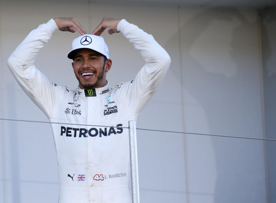 <p>Mercedes driver Lewis Hamilton of Britain poses on the podium for his team crew after winning the Japanese Formula One Grand Prix at Suzuka Circuit in Suzuka, central Japan, Sunday, Oct. 8, 2017. (AP Photo/Toru Takahashi)</p>