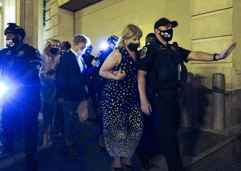 Sen. Rand Paul, R-Ky., center, and others, are escorted by Metropolitan Police after attending President Donald Trump's acceptance speech at the White House, Thursday night , Aug. 27, 2020, in Washington, after a crowd had enveloped Paul as he left the event and demanded that he acknowledge police shooting victim Breonna Taylor. (AP Photo/Yuki Iwamura)