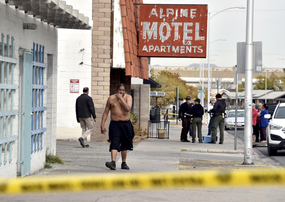 FILE - Anthony Todd Meadows, second left, walks from his residence after a fire displaced him from a three-story apartment building on Dec. 21, 2019 in Las Vegas. A confidential settlement has been reached in civil negligence lawsuits stemming from a December 2019 fire that killed six people at a downtown Las Vegas apartment building. Attorneys declined Thursday, March 9, 2023, to comment about the global resolution of cases against former Alpine Motel Apartments owner Adolfo Orozco and a corporate entity. (AP Photo/David Becker, File)