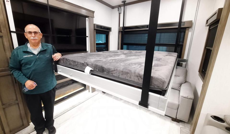 Randy Giancola, producer of the Pittsburgh RV Show stands in the "man cave" area of the River Stone camper that has an extra bed that drops down from the ceiling. The room of the camper has a 70-inch television, fire place, two couches and its own restroom.