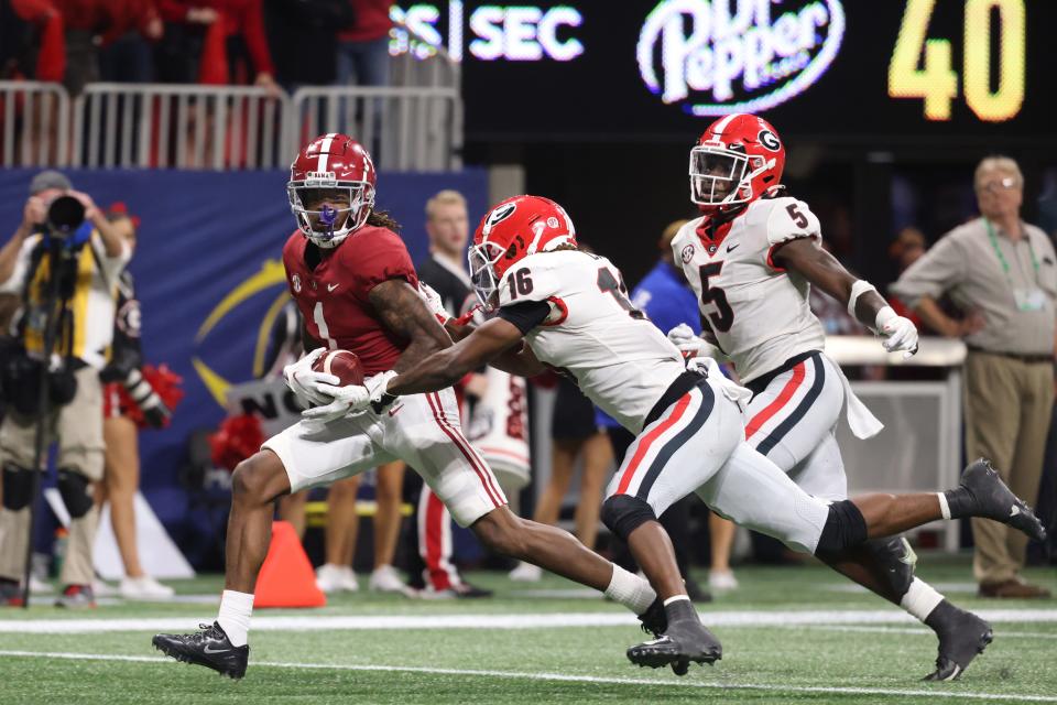 Alabama wide receiver Jameson Williams outruns Georgia defensive back Lewis Cine (16)  for a touchdown during the third quarter of the SEC championship game at Mercedes-Benz Stadium.