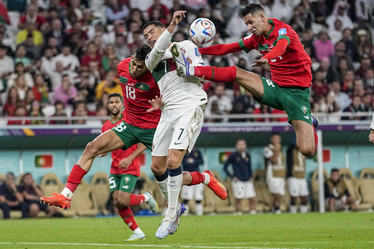 Morocco's Bilal El Khannous, right, fights for the ball with Portugal's Cristiano Ronaldo during the World Cup quarterfinal soccer match between Morocco and Portugal, at Al Thumama Stadium in Doha, Qatar, Saturday, Dec. 10, 2022. (AP Photo/Ariel Schalit)