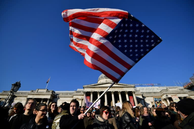 A protester waves the US flag during the 'Women's March' in Trafalgar Square in London on January 21, 2017 as he joins thousands of others as part of a global day of protests against new US President Donald Trump