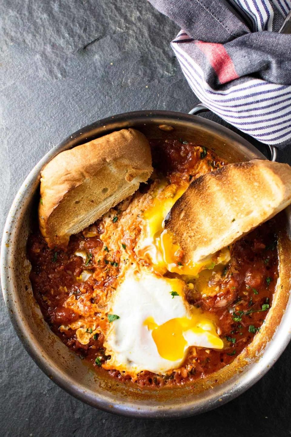 Eggs baked in tomato sauce with bread for dunking.