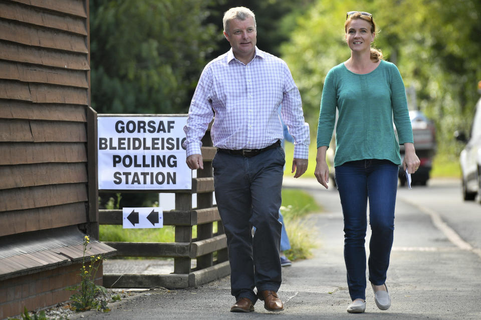 Conservative lawmaker Chris Davies and his wife Liz Davies leave Llyswen and Boughrood Community Hall in Llyswen, Wales, Thursday Aug. 1, 2019, after voting in the Brecon and Radnorshire by-election. New British Prime Minister Boris Johnson is facing his first electoral test _ a special election that could see the Conservative government’s working majority in Parliament cut to just one vote. Voters are electing a new lawmaker for the seat of Brecon and Radnorshireafter the Conservative incumbent, Chris Davies, was ousted. (Ben Birchall/PA via AP)