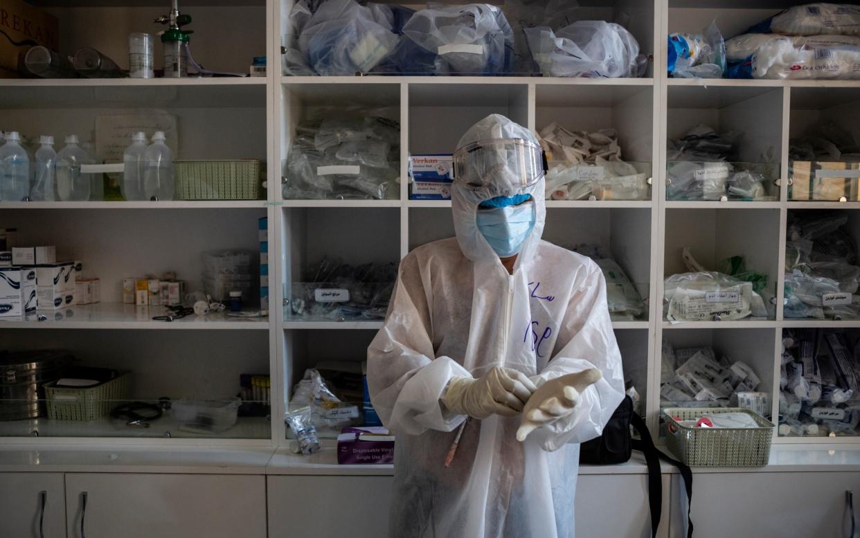 A doctor puts on PPE before tending to patients in Sulaymaniyah, Iraq - Hawre Khalid/Getty Images