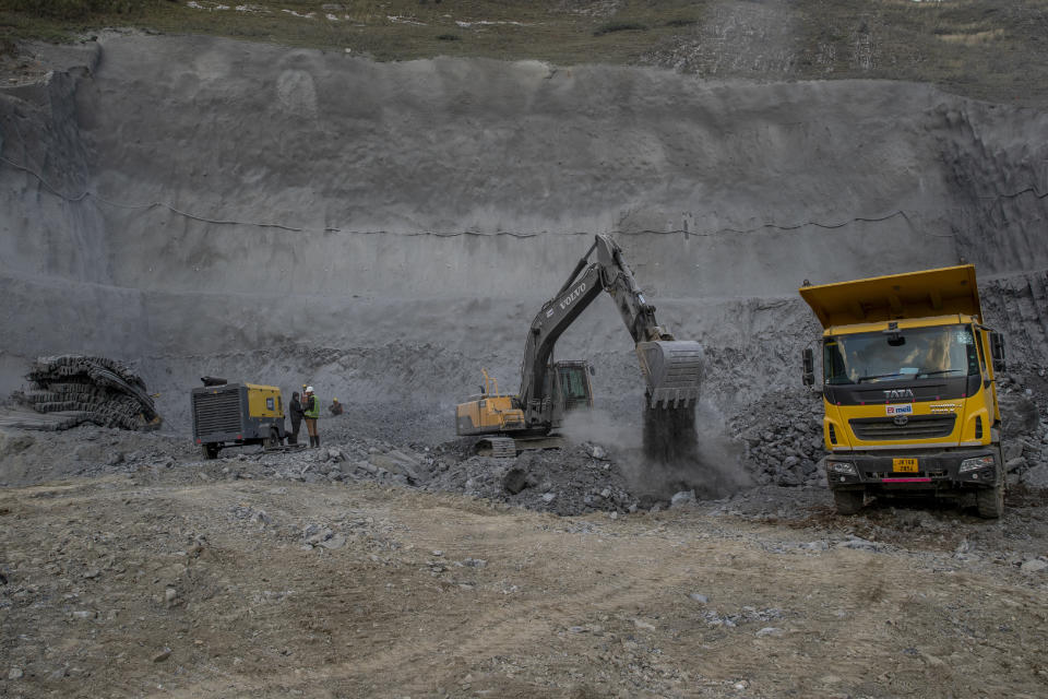 Land movers work to clear rocks and boulders as they work at the entrance of Nilgrar Tunnel in Baltal area northeast of Srinagar, Indian controlled Kashmir, Tuesday, Sept. 28, 2021. High in a rocky Himalayan mountain range, hundreds of people are working on an ambitious project to drill tunnels and construct bridges to connect the Kashmir Valley with Ladakh, a cold-desert region isolated half the year because of massive snowfall. The $932 million project’s last tunnel, about 14 kilometers (9 miles) long, will bypass the challenging Zojila pass and connect Sonamarg with Ladakh. Officials say it will be India’s longest and highest tunnel at 11,500 feet (3,485 meters). (AP Photo/Dar Yasin)