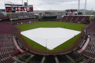 The tarp covers the field as it rains before the start of a baseball game between the Baltimore Orioles and Cincinnati Reds on Friday, May 3, 2024, in Cincinnati. (AP Photo/Carolyn Kaster)