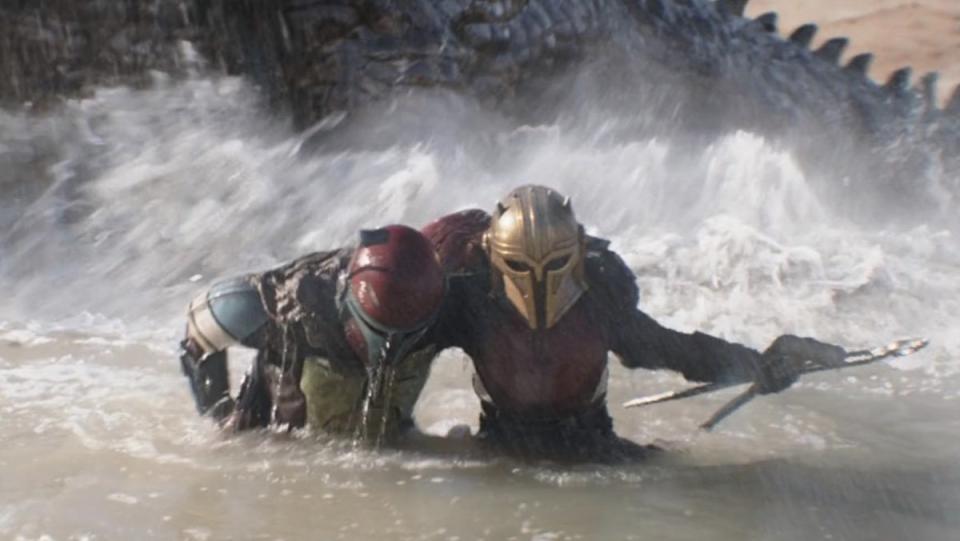 The Armorer carries another Mandalorian out of the water and a giant monster on The Mandalorian