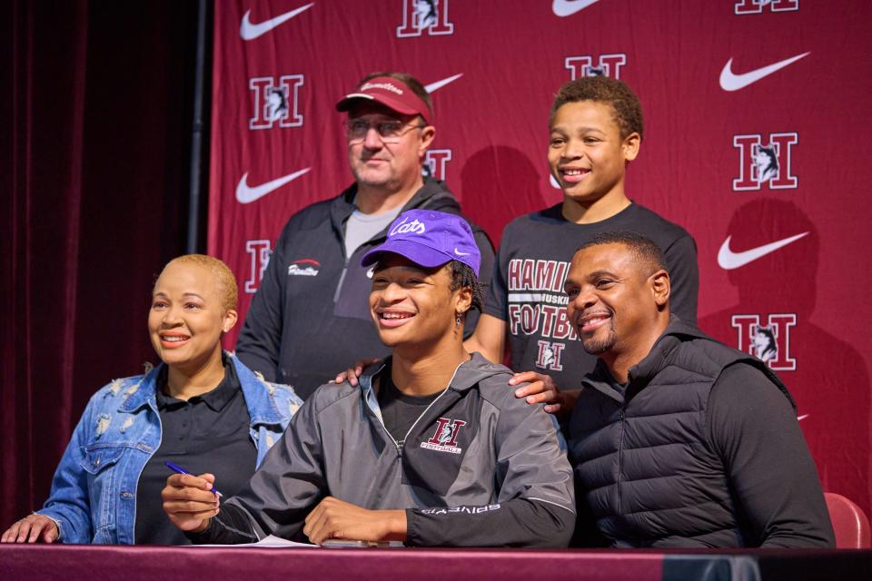 Tre Spivey, his family and coach Michael Zdebski pose for a photo during the signing day ceremony at the Hamilton High School auditorium on Dec. 21, 2022, in Chandler.