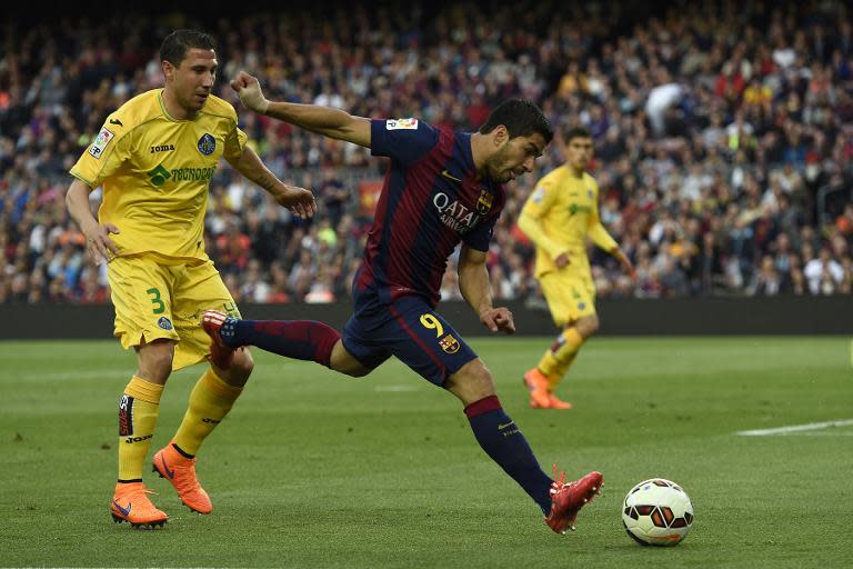 Barcelona's forward Luis Suarez (R) vies with Getafe's defender Roberto Lago (L) during the Spanish league football match on April 28, 2015