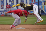 San Diego Padres' Jurickson Profar (10) tumbles over Cincinnati Reds shortstop Eugenio Suarez, left, after being tagged out on an attempted steal of second base in the fifth inning of a spring training baseball game Tuesday, March 23, 2021, in Peoria, Ariz. (AP Photo/Sue Ogrocki)