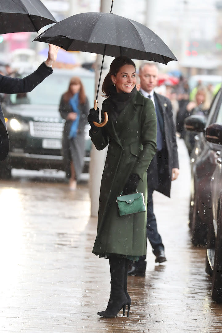 The Duchess of Cambridge kept chic in the rain during a trip to Blackpool courtesy of a belted Sportmax coat. She finished the ensemble with a £158 Michael Kors dress and matching £430 Manu Atelier handbag. [Photo: Getty]