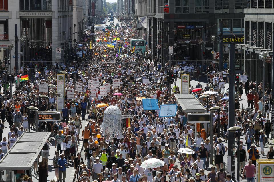 People mostly without face masks attend a demonstration with the slogan ‚The end of the pandemic - freedom day' - against coronavirus restrictions in Berlin, Germany, Saturday, Aug. 1, 2020. It comes amid increasing concern about an upturn in infections in Germany. (AP Photo/Markus Schreiber)