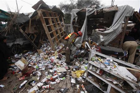 A rescue worker collects evidence at the site of a bomb blast on outskirts of Peshawar March 14, 2014. REUTERS/Fayaz Aziz
