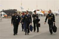 Military visitors walk during the sandstorm at the Dubai Airshow November 17, 2013. REUTERS/Ahmed Jadallah