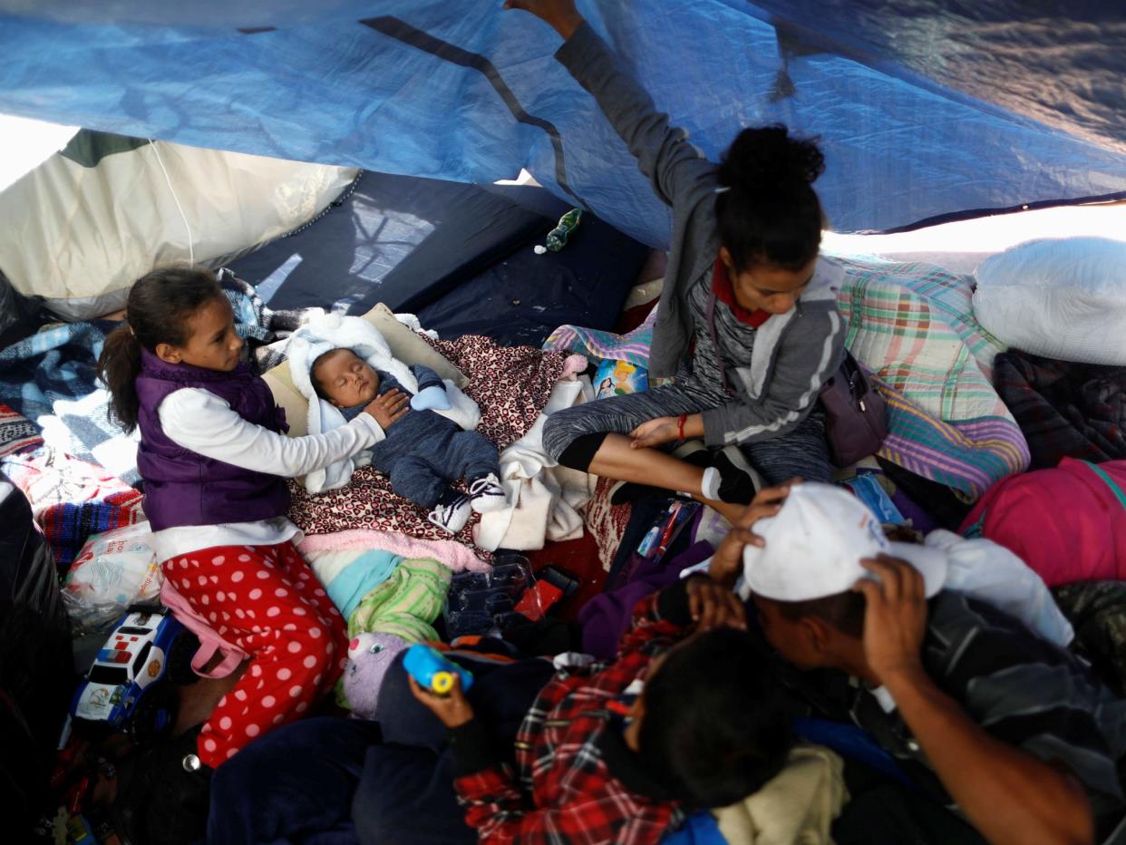 Children traveling with a caravan of migrants from Central America to the US are pictured under a plastic tarp at a camp near the San Ysidro checkpoint in Tijuana, Mexico: REUTERS/Edgard Garrido