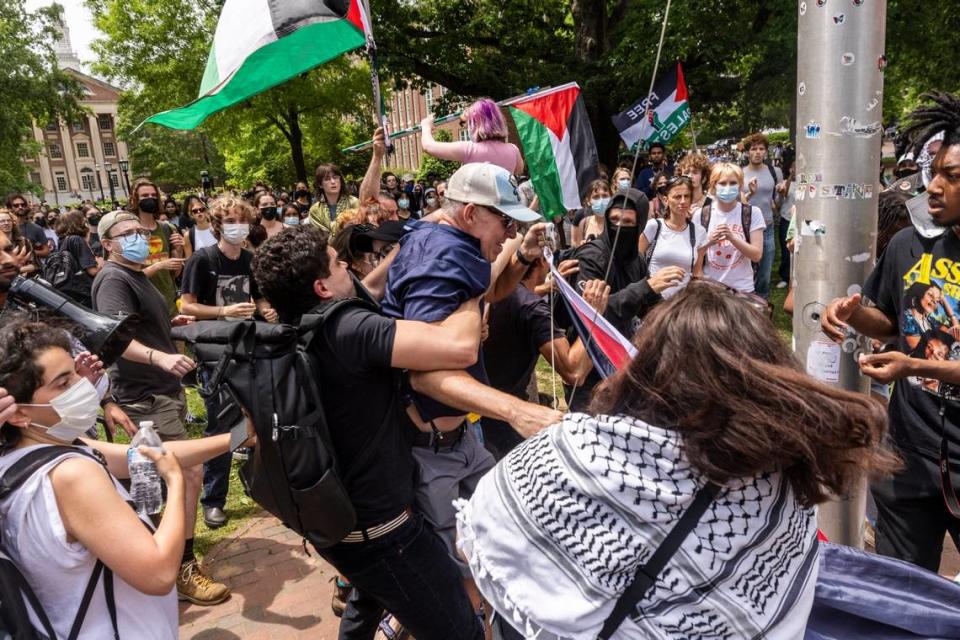 Pro-Palestinian demonstrators struggle with a counter-protester as Pro-Palestinian demonstrators replace an American flag with a Palestinian flag Tuesday, April 30, 2024 at UNC-Chapel Hill. Police removed a “Gaza solidarity encampment” earlier Tuesday morning. Travis Long/tlong@newsobserver.com