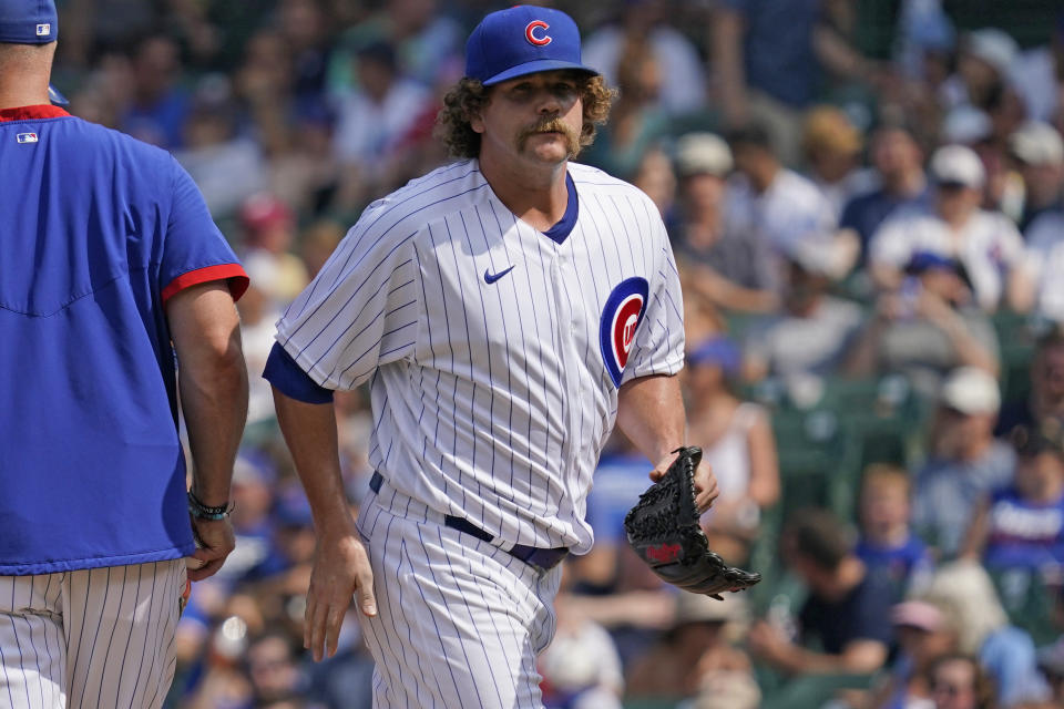 Chicago Cubs relief pitcher Andrew Chafin, right, walks to the dugout after turning the ball over to manager David Ross during the seventh inning of a baseball game against the Arizona Diamondbacks in Chicago, Saturday, July 24, 2021. (AP Photo/Nam Y. Huh)