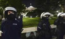 Police stand guard while protesters block the parliament in Warsaw, Poland, Wednesday Oct. 28, 2020. People across Poland stayed off their jobs and huge crowds poured onto the streets for a seventh straight day of protests Wednesday, enraged over a top court ruling that bans abortions in cases of fetal abnormalities. (AP Photo/Czarek Sokolowski)