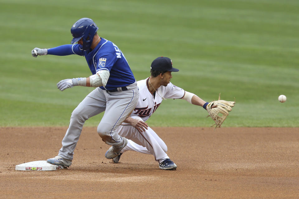 Kansas City Royals' Whit Merrifield, left, makes it safely to second base against Minnesota Twins' Andrelton Simmons, right, after hitting a ground ball to right fielder Alex Kirilloff during the first inning of a baseball game Sunday, May 30, 2021, in Minneapolis. (AP Photo/Stacy Bengs)