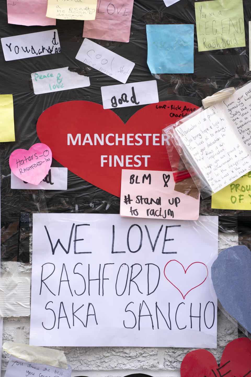 A view of the messages of support left on a mural of Manchester United striker and England player Marcus Rashford, on the wall of the Coffee House Cafe on Copson Street, in Withington, Manchester, England, Tuesday July 13, 2021. The mural was defaced with graffiti in the wake of England losing the Euro 2020 soccer championship final match to Italy. (AP Photo/Jon Super)