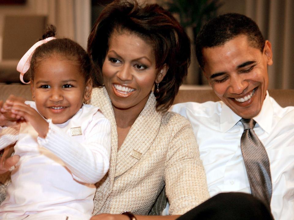 Barack and Michelle Obama smile with their daughter Sasha