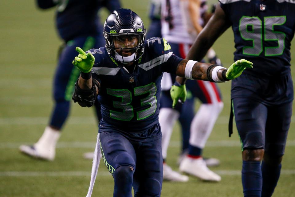 Seattle Seahawks strong safety Jamal Adams (33) celebrates with defensive end Benson Mayowa (95) after making a tackle against the New England Patriots during the fourth quarter at CenturyLink Field.