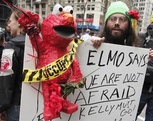 An Occupy Wall Street movement supporter holds up a sign with Elmo before a march from Zuccotti Park to Union Square to protest perceived police brutality in New York, March 24, 2012.