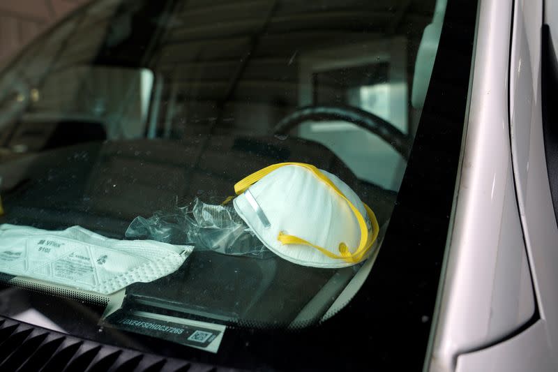 A protective face mask is seen on the dashboard of a REACT EMS ambulance in Shawnee