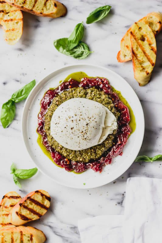 <p>Fork in the Kitchen</p><p>Layers of a sticky tomato jam, fresh pesto, and creamy burrata turn into a delicious dip and spread for crostini.</p><p><strong>Get the recipe: <a href="https://www.forkinthekitchen.com/pesto-tomato-burrata-spread/" rel="nofollow noopener" target="_blank" data-ylk="slk:Pesto Tomato Burrata Salad;elm:context_link;itc:0;sec:content-canvas" class="link rapid-noclick-resp"><em>Pesto Tomato Burrata Salad</em></a></strong></p>