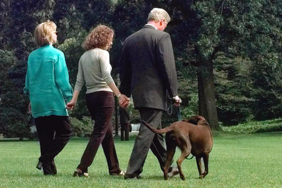 FILE - President Bill Clinton, daughter Chelsea and first lady Hillary Clinton walk with their Labrador "Buddy" to board Marine One on the South Lawn of the White House in Washington, Aug.18, 1998. The first family will travel to Martha's Vineyard, Mass. for a two week vacation. (AP Photo/J. Scott Applewhite, File)