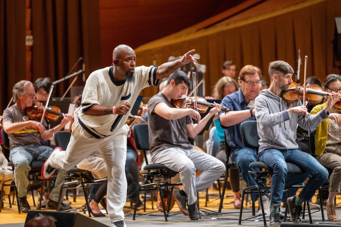 Musicians with the Kansas City Symphony concentrate on their playing under the direction of conductor Tim Davies while hip-hop artist Tech N9ne practices an energetic performance of one of his songs. Emily Curiel/ecuriel@kcstar.com