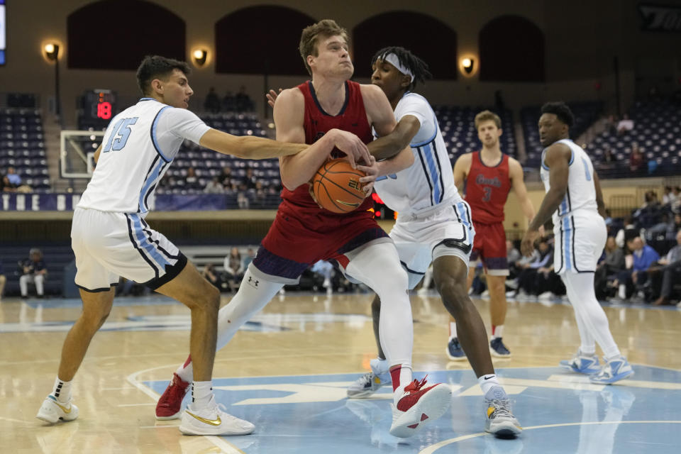 Saint Mary's center Mitchell Saxen, center, drives with the ball as San Diego guard Neel Beniwal, left, and center Steven Jamerson II, right, defend during the first half of an NCAA college basketball game Thursday, Feb. 16, 2023, in San Diego. (AP Photo/Gregory Bull)