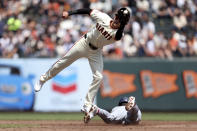 San Francisco Giants shortstop Nick Ahmed, left, fields the throw on a stolen base by Washington Nationals Drew Milas, right, during the third inning of a baseball game in San Francisco, Wednesday, April 10, 2024. (AP Photo/Jed Jacobsohn)