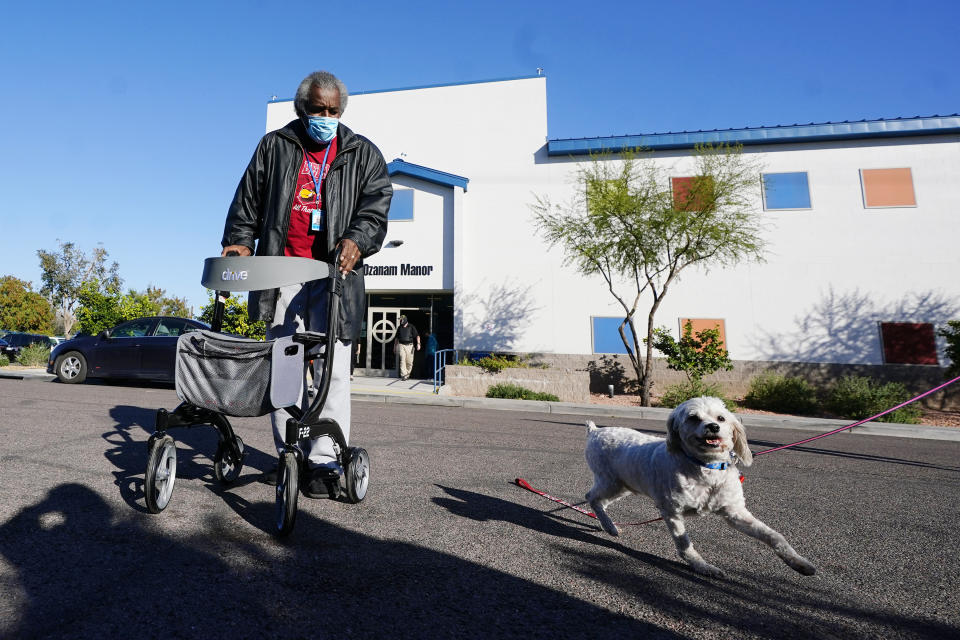 Lovia Primous, 67, walks across the street from Ozanam Manor temporary housing for people 50 and up, Monday, Jan. 24, 2022, in Phoenix. A stroke started 67-year-old Army veteran Primous on his downward spiral, costing him his job and forcing him to sleep in his Honda Accord. He was referred to the transitional shelter after recovering from COVID-19. (AP Photo/Ross D. Franklin)