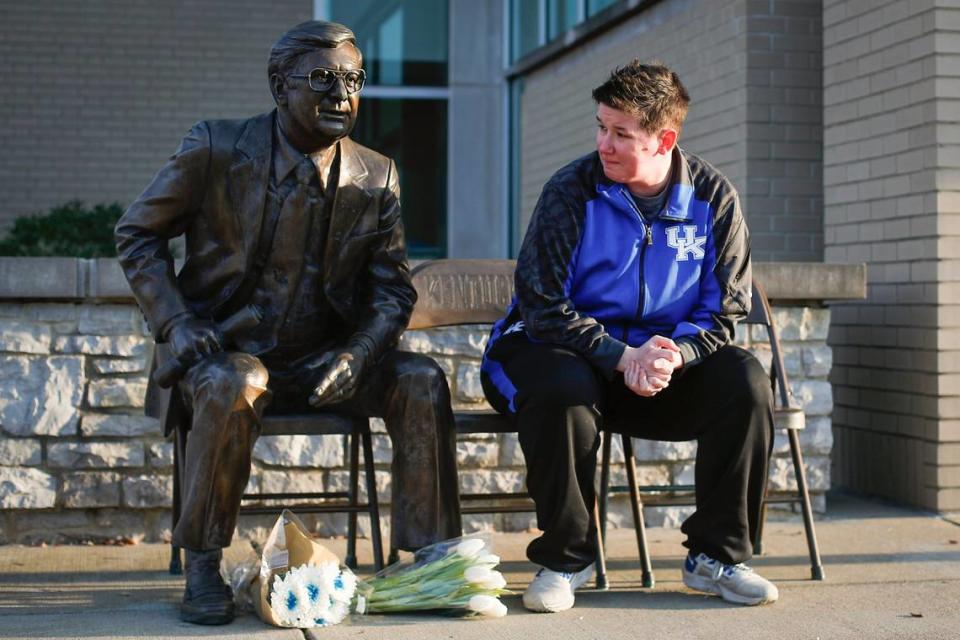 Longtime Kentucky sports fan Beth Casey, of Huntington, W.Va., reflects near a statue of former Kentucky basketball coach Joe B. Hall near Memorial Coliseum in Lexington on Saturday. Hall died early Saturday morning at the age of 93.