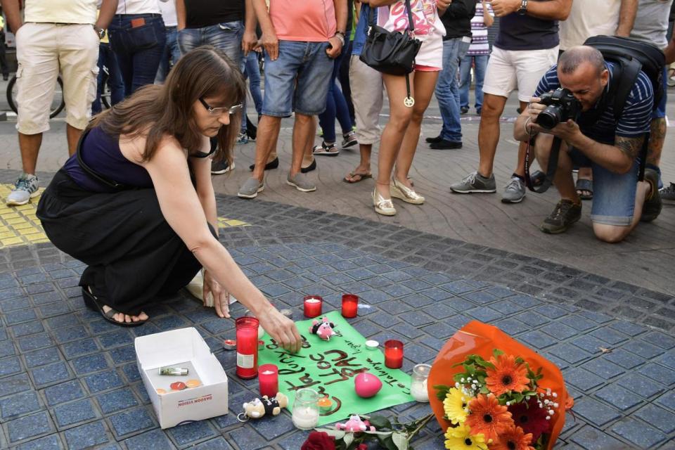 A woman lays tributes to the victims of the Barcelona terror attack (AFP/Getty Images)