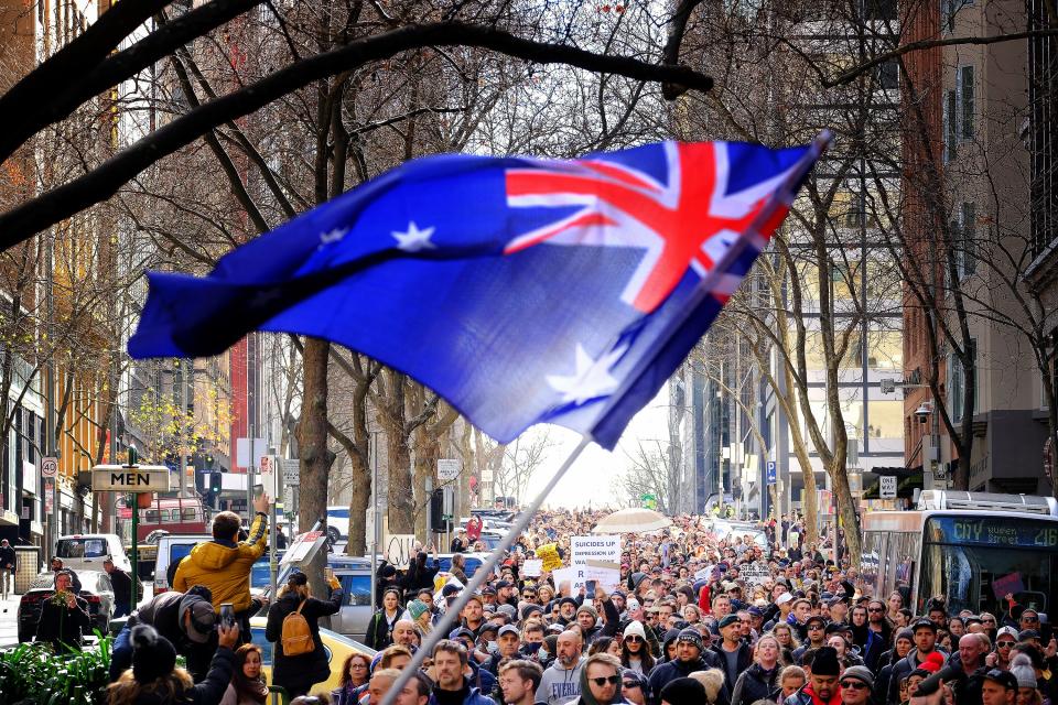 Anti-lockdown protesters march in Melbourne on Saturday (EPA)