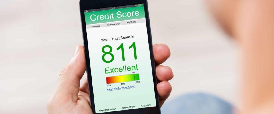 Man Holding Smart Phone Showing Credit Score Application On A Screen